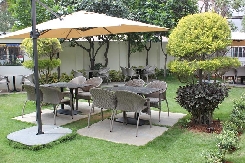 Lush green garden view at Marigold restaurant Whitefield